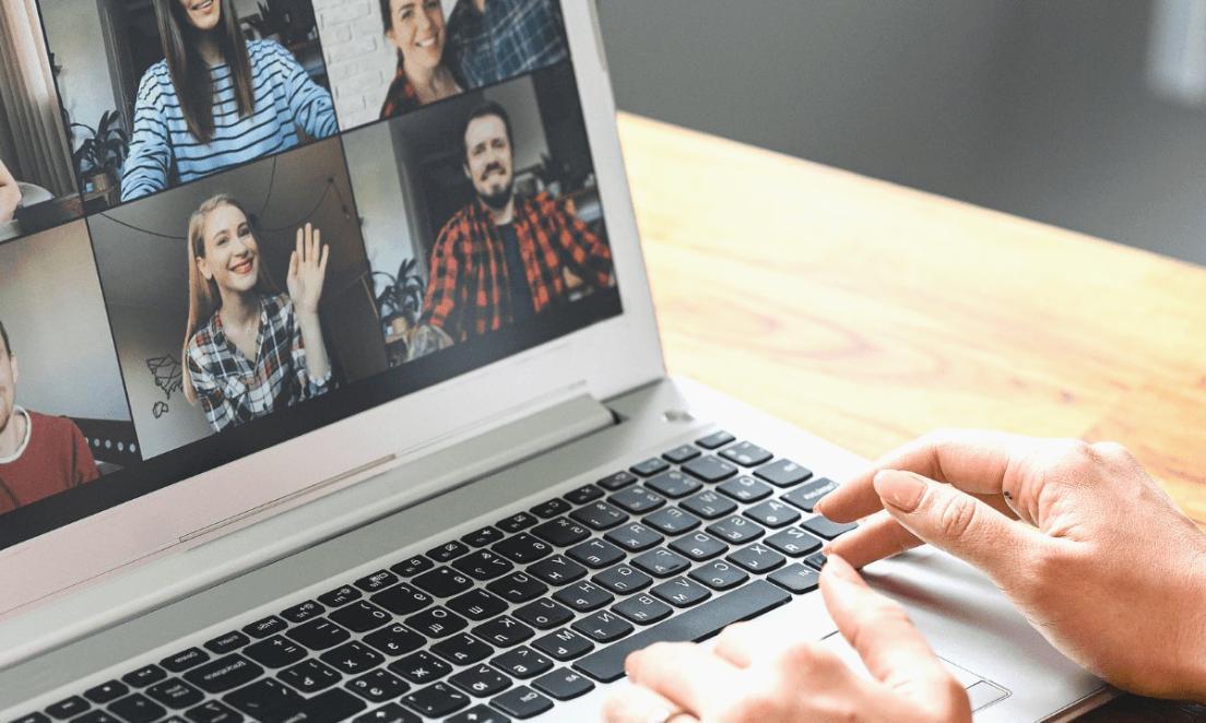Person reviewing financial documents at home workspace with laptop and coffee